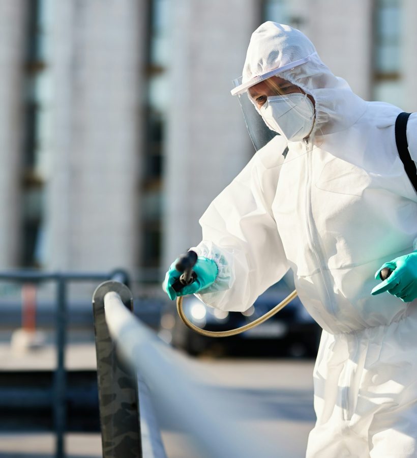 Disinfectant worker cleaning city streets during COVID-19 pandemic.